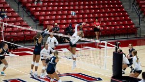 An image of Utah Tech's women's volleyball team in the middle of a match.